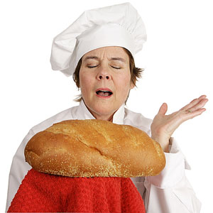 a baker presenting a freshly baked loaf of bread